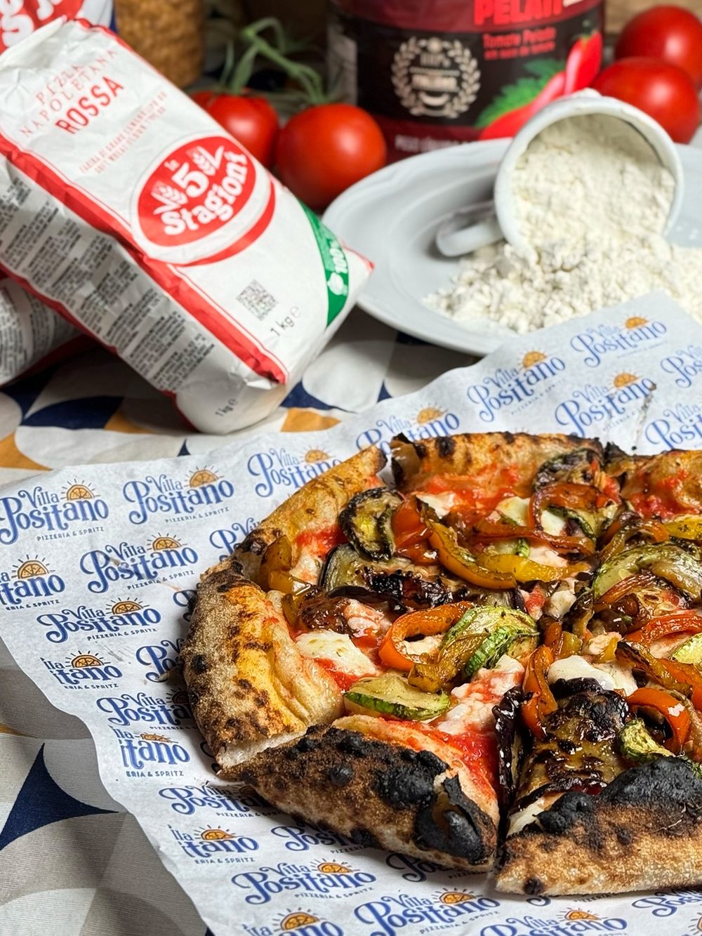 Farinha italiana, tomate pelati e pizza sobre o papel da Villa Positano